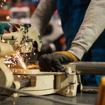 Technician worker cutting metal with many sharp sparks. Using equipments to cat iron